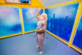 And image of a mum and toddler dancing in a dance themed beach hut at sooty land